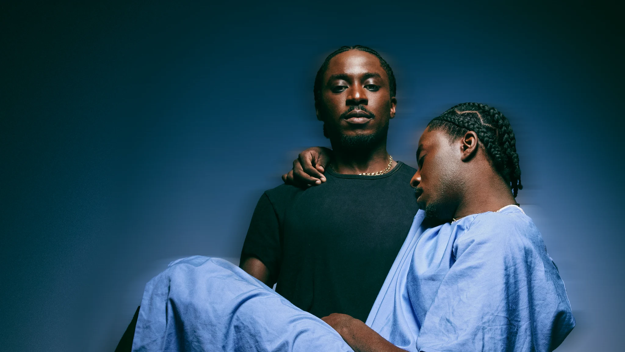 Gabriel Badejo standing behind an image of himself in a hospital gown